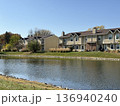Suburban townhouses near calm lake with blue sky autumn landscape 136940240