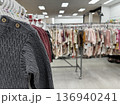 Clothing rack in modern retail store with sweaters and hangers 136940241