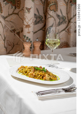 Pasta with shrimp in creamy pesto sauce 136941900