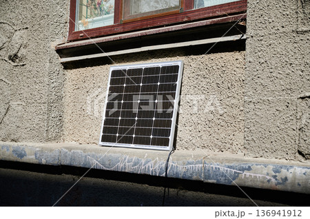 Photovoltaic solar panel in front of historical building. Concept of integration of sustainable renewable energy sources into old architecture. 136941912