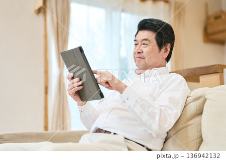 タブレットで読書をするアジア人シニア男性 タブレットで読書をするアジア人シニア男性 136942132
