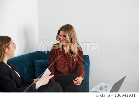 Women have a discussion in an office setting during a business meeting about work topics and tasks 136942931