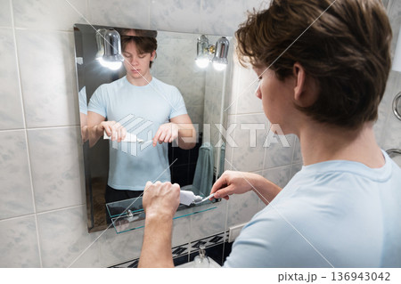 Applying toothpaste on toothbrush at sink. Brushing Teeth Applying toothpaste on toothbrush at sink. Brushing Teeth 136943042