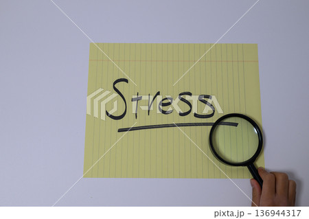 ストレスの文字と虫眼鏡を持つ手 136944317