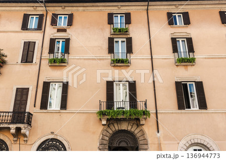 Traditional residential building facade with balconies and shutters in rome italy 136944773