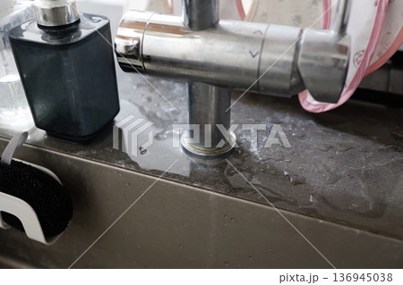 濡れた蛇口根元のキッチン水回り。 136945038