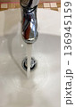 Water runs from the water tap in the bathroom. 136945159