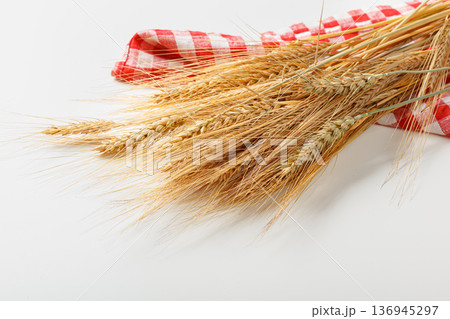 Wheat stalks placed on a red and white checkered cloth for display and cooking use Wheat stalks placed on a red and white checkered cloth for display and cooking use 136945297