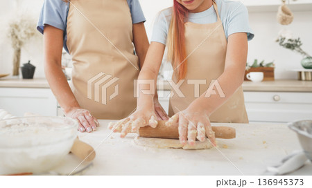 People prepare dough together in a kitchen 136945373