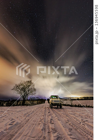 満天の星と雪道に停まるSUVのナイトシーン 136945598