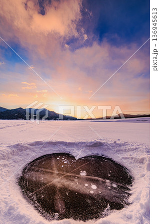 氷に閉じ込められたアイスバブルとハート形の自然美（糠平湖） 136945613