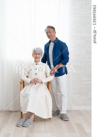 椅子に座る女性と側に立つ男性　ライフスタイルイメージ 136945662