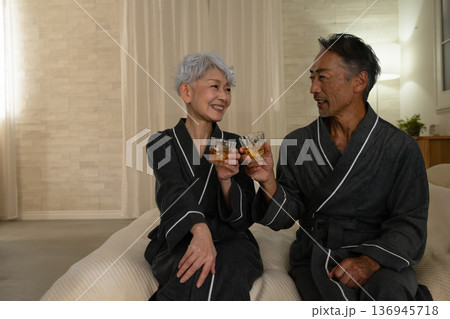 ガウンコート姿でベッドに座るシニア夫婦 ライフスタイルイメージ ガウンコート姿でベッドに座るシニア夫婦 ライフスタイルイメージ 136945718