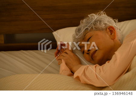 ベッドで眠るシニア女性　ライフスタイルイメージ 136946148