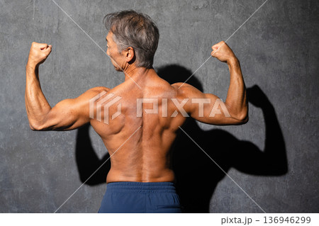 上半身裸でボディビルのポージングをとるシニア男性 スポーツイメージ 上半身裸でボディビルのポージングをとるシニア男性 スポーツイメージ 136946299