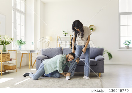 Couple quarrel and breakup at home, clingy man pleading with woman not to leave 136946779