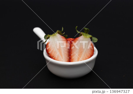 真っ赤なイチゴの白い断面　黒い背景の中のイチゴの素材写真 136947327