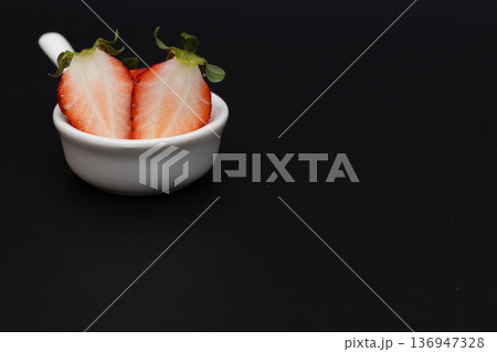 真っ赤なイチゴの白い断面　黒い背景の中のイチゴの素材写真 136947328