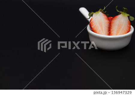 真っ赤なイチゴの白い断面　黒い背景の中のイチゴの素材写真 136947329