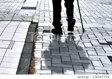 日本の横浜都市景観段差…杖の高齢男性、…危険が多い歩道に黒い影が揺れる…人生とは… 136947359
