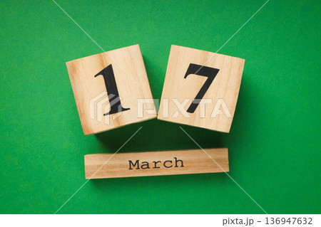 Wooden blocks showing the date March 17 on green backdrop 136947632