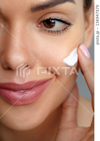 Skin care. Woman with beauty face touching healthy facial skin portrait. Beautiful smiling girl model with natural makeup touching glowing hydrated skin. 136947870