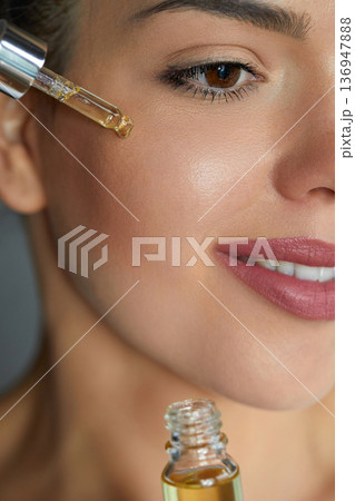 Beauty, skincare and serum with face of woman for facial, product or self care. Health and wellness with girl model and cosmetics for collagen, vitamin c or essential oil. 136947888