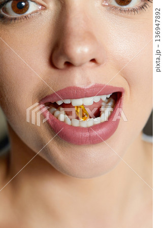 Vitamin And Supplement. Closeup Of Beautiful Young Woman Taking Yellow Fish Oil Pill Vitamin And Supplement. Closeup Of Beautiful Young Woman Taking Yellow Fish Oil Pill 136947892