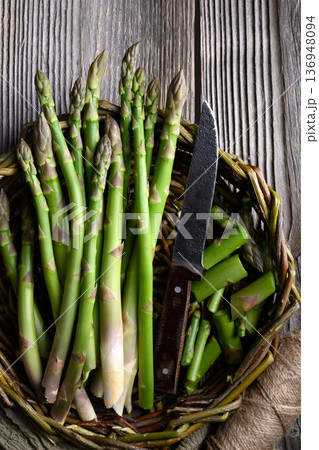 Raw green asparagus arranged in wicker basket Raw green asparagus arranged in wicker basket 136948094