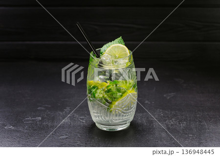 Fresh mojito cocktail with lime, mint and ice in glass on dark background 136948445