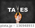 The man's hand holding scissors forms the letter x, creating the word "taxes". 136948933
