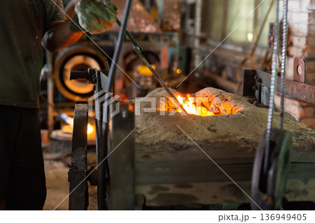 Foundry ferrous metal is melted in an induction furnace of metallurgical plant 136949405