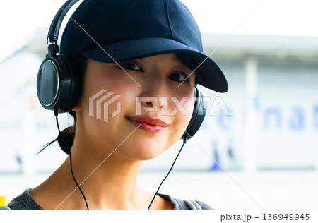 ヘッドホンで音楽を楽しむ女性 ■撮影協力：関西国際空港（KIX） 136949945