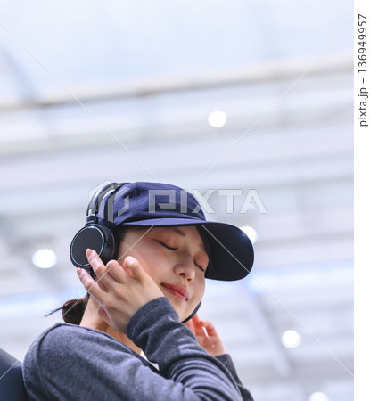 ヘッドホンで音楽を楽しむ女性 ■撮影協力:関西国際空港(KIX) ヘッドホンで音楽を楽しむ女性 ■撮影協力:関西国際空港(KIX) 136949957