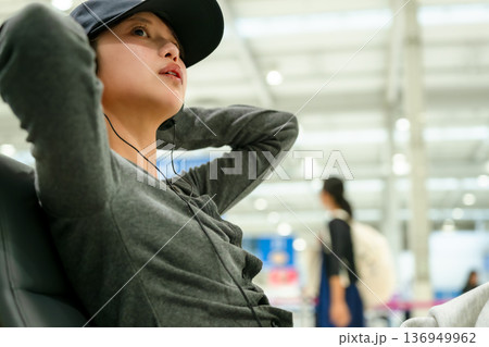 空港で音楽を聴く女性 ■撮影協力：関西国際空港（KIX） 136949962