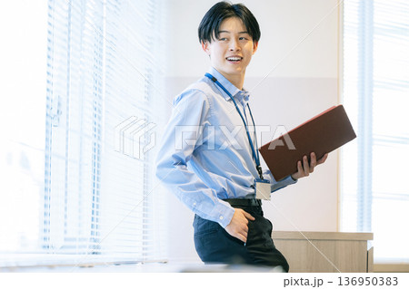 資料を見て考えるビジネスマン 136950383