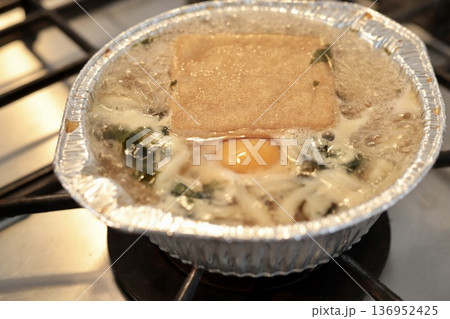 アルミ鍋の鍋焼きうどんを火にかけて煮立たせているところ 136952425