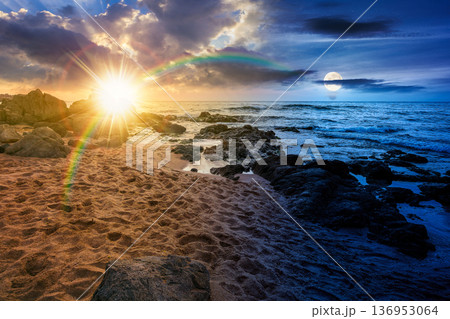 sandy beach landscape. day meet night. sun and moon over beautiful coastal seascape scenery. astrology background for autumn equinox vacation at the shore of black sea with rocks 136953064