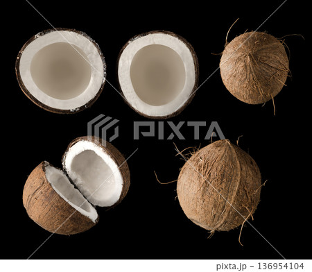 Coconut divided into two equal parts, view from the top, on a black background in isolation, collage Coconut divided into two equal parts, view from the top, on a black background in isolation, collage 136954104