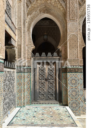 Carved stone gate arch, carved wooden architectural details, Medersa bou Inania, Fez, Morocco Carved stone gate arch, carved wooden architectural details, Medersa bou Inania, Fez, Morocco 136955736