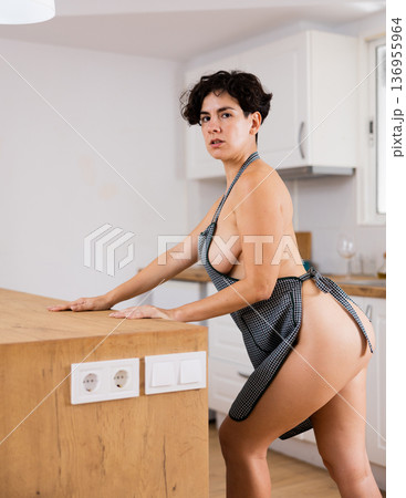 Naked woman in apron posing in kitchen 136955964