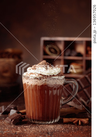 Hot chocolate topped with whipped cream and sprinkled with chocolate chips. 136957026