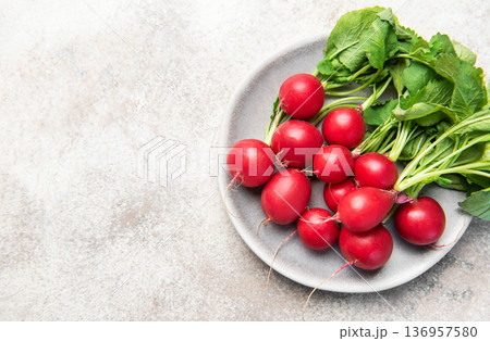 Fresh spring radishes with green leaves on plate Fresh spring radishes with green leaves on plate 136957580