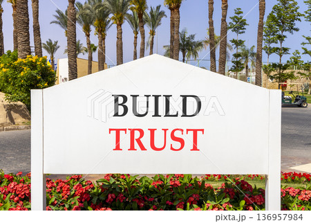 Build trust symbol. Concept words Build trust on beautiful big white road sign. Beautiful blue sky palm trees background. Business and build trust concept, copy space. Build trust symbol. Concept words Build trust on beautiful big white road sign. Beautiful blue sky palm trees background. Business and build trust concept, copy space. 136957984