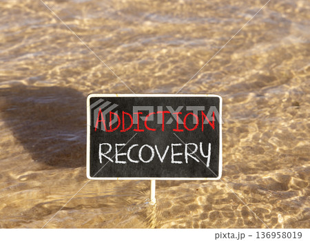 Addiction recovery symbol. Concept words Addiction recovery on beautiful black blackboard. Beautiful Red sea water background. Psychology addiction recovery concept. Copy space. Addiction recovery symbol. Concept words Addiction recovery on beautiful black blackboard. Beautiful Red sea water background. Psychology addiction recovery concept. Copy space. 136958019