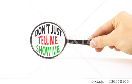 Tell or show symbol. Concept words Do not just tell me, show me on beautiful magnifying glass. Businessman's hand. Beautiful white background. Business tell or show concept. Copy space. Tell or show symbol. Concept words Do not just tell me, show me on beautiful magnifying glass. Businessman's hand. Beautiful white background. Business tell or show concept. Copy space. 136958106
