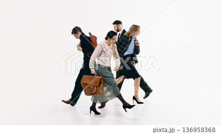 Four professionals walking in synchronized formation against white background. Four professionals walking in synchronized formation against white background. 136958368