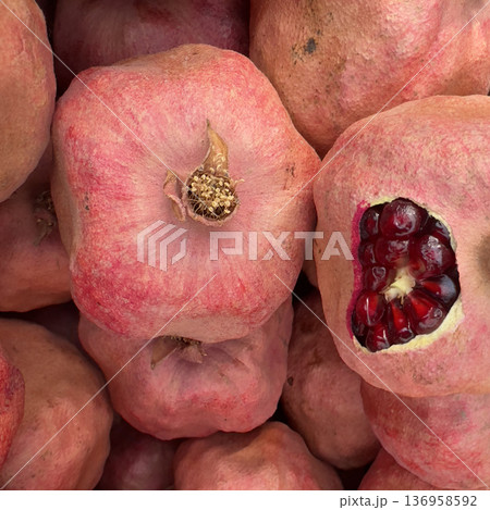Bunch of red pomegranates are piled on top of each other. 136958592