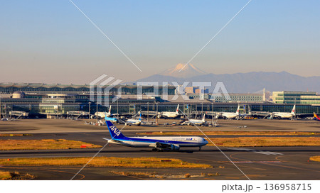 羽田空港第一ターミナル展望デッキから見た富士山と離陸に向けて走行中の国内線飛行機 136958715