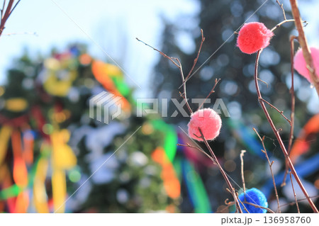 Spring festival decorations with vibrant colorful pom-poms and ribbons on birch branches outdoors Spring festival decorations with vibrant colorful pom-poms and ribbons on birch branches outdoors 136958760